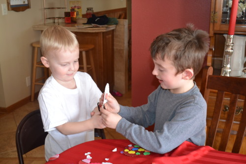 Bennett (right) showing Thomas how the hole puncher works.