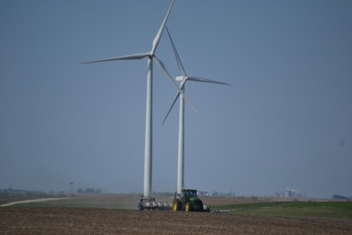 Planting corn under the windmills. Ethanol plant in the background with the smokestack. 