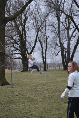 Ava gliding through the air with hard pushes from Aunt Jenny