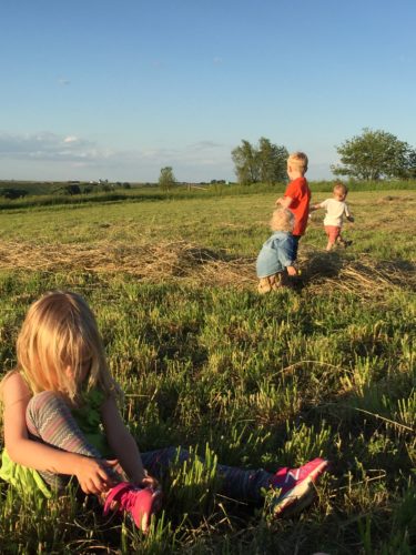 Anna pulling on her shoes so she could play in the windrow with the boys. 